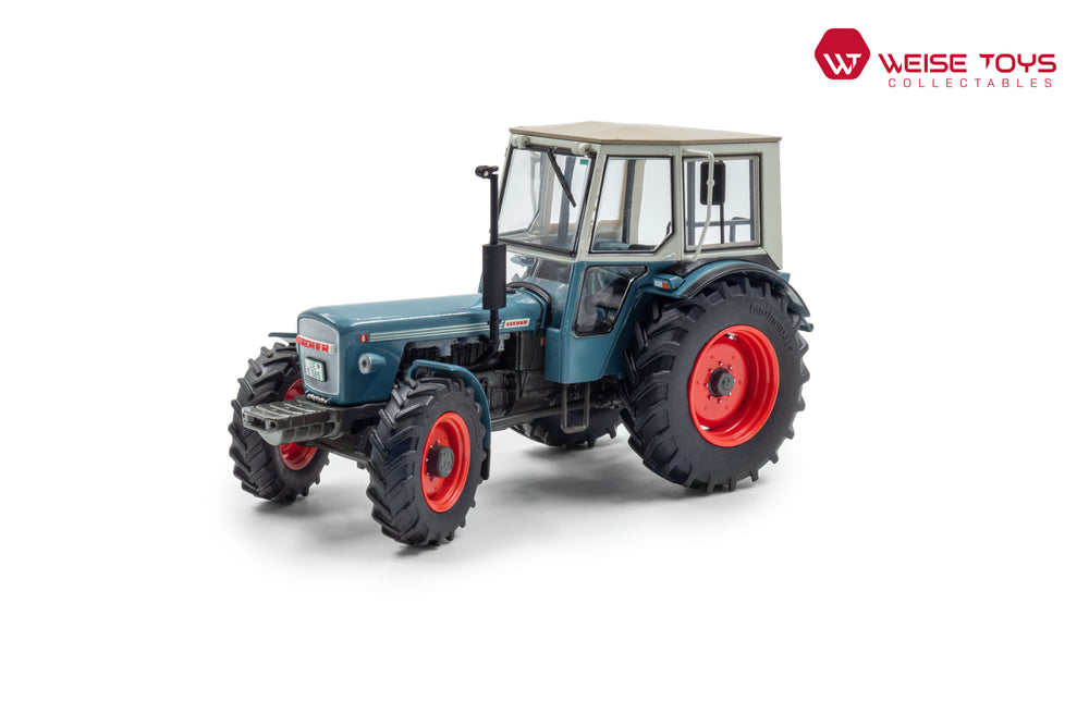 zij/vooraanzicht van een blauwe Eicher Wotan ll miniatuur tractor in de schaal 1 op 32 met cabine en frontgewicht.