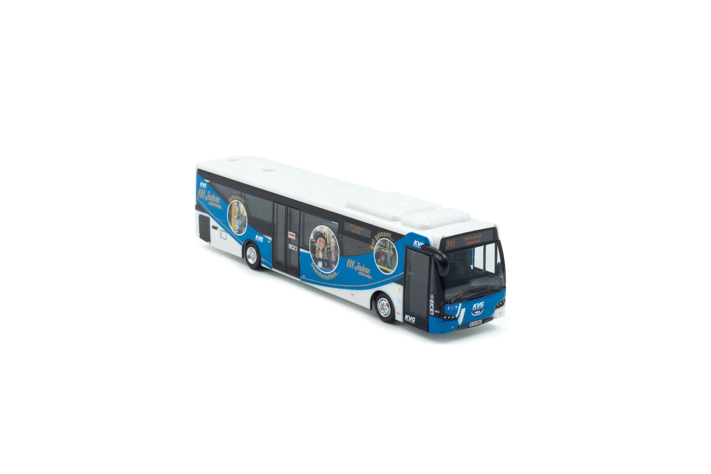 Zij/vooraanzicht van een wit/blauwe VDL Citea LLE miniatuurbus in de schaal 1:87 van het merk Holland Oto. In de uitvoering van KVB 111 jarige jubileum. Lijn 391 bestemming Helmstedt Bahnhof.