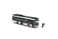 Zij/vooraanzicht van een wit/bronze Ebusco 2.2. miniatuurbus in de schaal 1:87 van het merk Holland Oto. In de Promo uitvoering met laadstation.