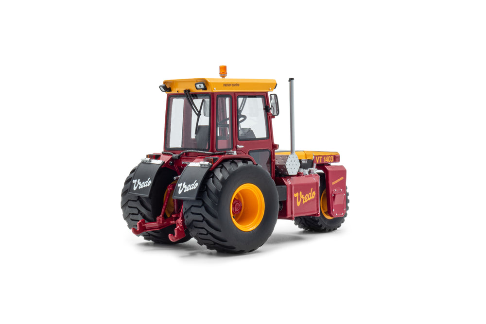 zij/achteraanzicht van een rode Vredo VT1403 miniatuur tractor in de schaal 1 op 32. Een driewieler.